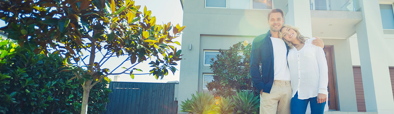 couple standing in front of house