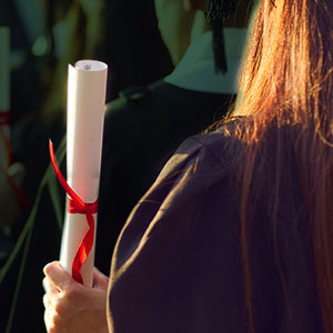 graduate holding her diploma