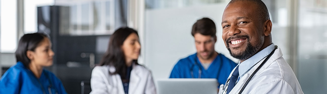 Smiling doctor with other doctors in the background