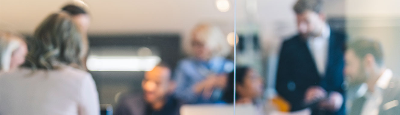 people in office behind glass